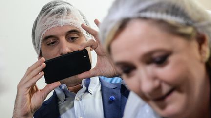 Florian Philippot photographie Marine Le Pen lors&nbsp;de la visite d'une fabrique de chocolat, le 8 mars 2017 à Chalezeule (Doubs). (SEBASTIEN BOZON / AFP)