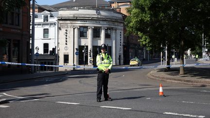 Un policier boucle une rue du centre-ville de Nottingham (Royaume-Uni), le 13 juin 2023, après la découverte de trois personnes tuées. (DARREN STAPLES / AFP)