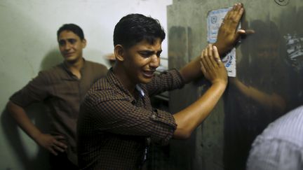 Des amis du Palestinien de 17 ans, mort apr&egrave;s avoir &eacute;t&eacute; touch&eacute; par des tirs isra&eacute;liens, pleurent &agrave; la morgue de l'h&ocirc;pital de Gaza, le 31 juillet 2015. (MOHAMMED SALEM / REUTERS)