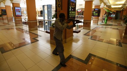 Un policier k&eacute;nyan arm&eacute; &agrave; la recherche des hommes arm&eacute;s et masqu&eacute;s qui ont ouvert le feu samedi 21 septembre 2013 sur les clients et le personnel d'un centre commercial de luxe &agrave; Nairobi (Kenya). (GORAN TOMASEVIC / REUTERS)