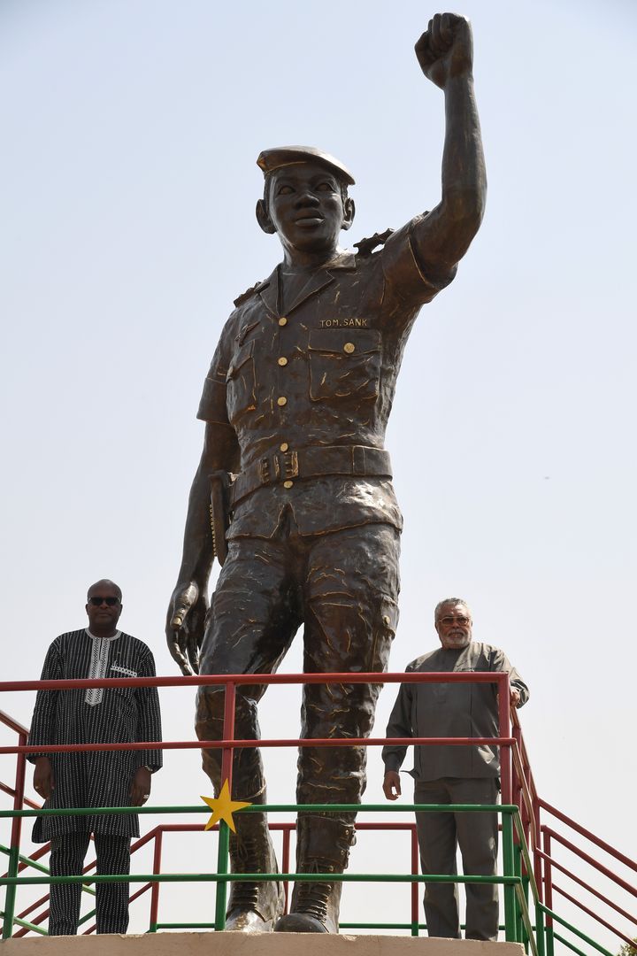 L'ancien président du Ghana, Jerry Rawlings (à droite) et le président du Burkina Faso, Roch Marc Christian Kabore (à gauche), sous la statue de bronze de l'ancien président du Burkina Faso, Thomas Sankara, lors de&nbsp;l'inauguration de son mémorial à Ouagadougou le 2 mars 2019. (ISSOUF SANOGO / AFP)