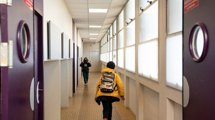 Deux élèves dans un couloir du collège François Villon à Paris, le 14 janvier 2022. (ALINE MORCILLO / HANS LUCAS / AFP)