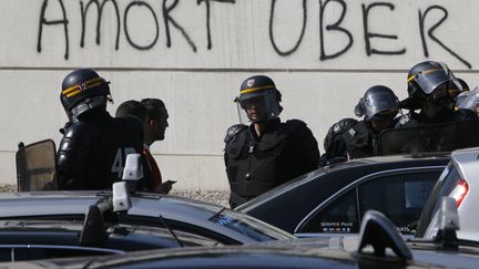 Des chauffeurs de taxis parisiens manifestent Porte Maillot &agrave; Paris, le 25 juin.&nbsp; ( CHARLES PLATIAU / REUTERS)