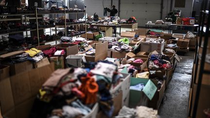 Une bénévole de l'association caritative MaMaMa trie des vêtements d'enfants donnés au siège de l'association à Saint-Denis, (Seine-Saint-Denis), le 12 novembre 2020. (CHRISTOPHE ARCHAMBAULT / AFP)