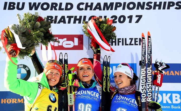 La Tchèque Gabriela Koukalova championne du monde du sprint entourée de l'Allemande Laura Dahlmeier (à gauche) et de la Française Anaïs Chevalier (à droite) peu habituée aux podiums protocolaires. (FRANCK FIFE / AFP)