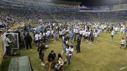 Des supporters sont secourus par d'autres après une bousculade lors d'un match de football entre l'équipe locale Alianza et le CD FAS, au stade Cuscatlan à San Salvador, le 20 mai 2023. (MILTON FLORES / AFP)