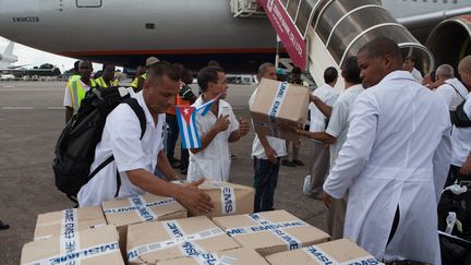 Les premiers membres de la d&eacute;l&eacute;gtion cubaine pour soigner Ebola en Afrique de l'Ouest &agrave; leur arriv&eacute;e &agrave; Freetown (Sierra Leone), le 2 octobre 2014.&nbsp; (FLORIAN PLAUCHEUR / AFP)