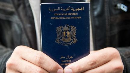 Un homme tient un passeport syrien à la gare de Lübeck, en Allemagne, le 8 septembre 2015. 
 ( DANIEL REINHARDT/DPA)