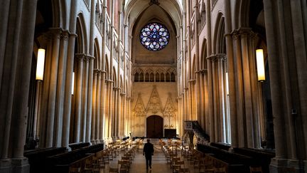 Un prêtre vérifie les sièges en respectant la distance sociale avant la messe à la cathédrale Saint-Jean de Lyon, le 23 mai 2020.
 (JEFF PACHOUD / AFP)