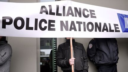 Un policier tient une pancarte du syndicat Alliance police nationale lors d'une manifestation contre la "haine des flics" à Nantes en mai 2016 (photo d'illustration). (JEAN-SEBASTIEN EVRARD / AFP)