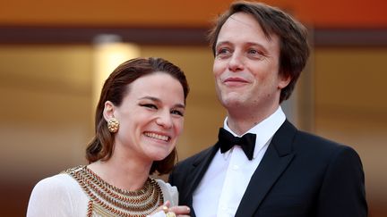 L'actrice australienne Valérie Pachner et l'acteur allemand August Diehl arrivent tout sourire à la projection du film Une vie cachée, dans lequel ils se donnent la réplique. (VALERY HACHE / AFP)