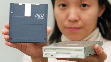 Une disquette HiFD 3,5 pouces et un lecteur de disquettes de 1997. (TORU YAMANAKA / AFP)