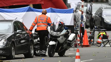 Un policier sécurise l'emplacement de la fusillade qui a fait trois morts mardi matin à Liège. (ERIC LALMAND / BELGA)