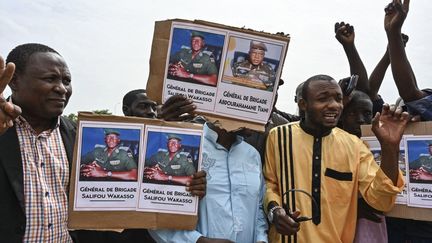 Des hommes brandissent des pancartes en faveur des putschistes à Niamey (Niger), le 6 août 2023. (AFP)