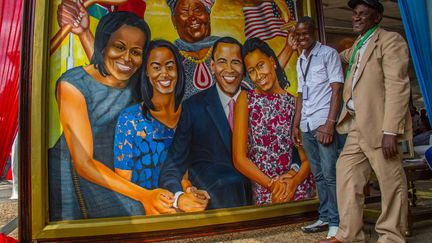 Deux hommes posent devant l'un des nombreux tableaux &agrave; l'effigie de Barack Obama. Ici, le pr&eacute;sident am&eacute;ricain est repr&eacute;sent&eacute; avec toute sa famille. (CITIZENSIDE/BONIFACE MUTHONI / CITIZENSIDE.COM)