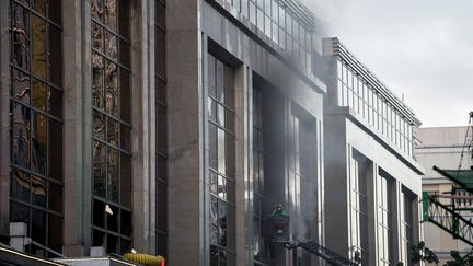 Un pompier casse une vitre du Resorts World Manila, le 2 juin 2017, un hôtel-casino situé près de l'aéroport international de Manille (Philippines), où s'est produit une attaque qui a fait au moins 36 morts.&nbsp; (NOEL CELIS / AFP)