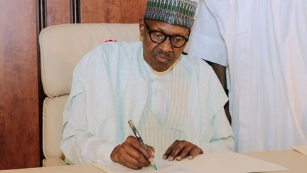 Le président nigérian Muhammadu Buhari écrit à l'Assemblée nationale à son retour de Londres, lundi 21 août 2017 à Abuja. (SUNDAY AGHAEZE / AFP)