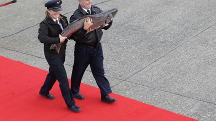 Des officiers d&eacute;barquent d'un avion d'Alaska airlines avec un saumon de plus de 20 kilos alors que la p&ecirc;che au filet est officiellement ouverte, Seatac (Washington, Etats-Unis), le 16 mai 2014. (TED S. WARREN / AP / SIPA)