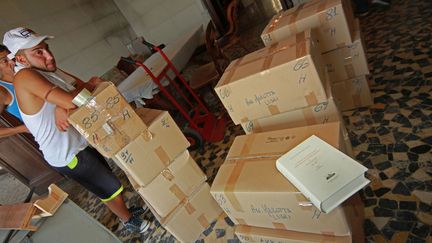 Des d&eacute;m&eacute;nageurs transportent les cartons contenant les ouvrages philosophiques de cette prestigieuse biblioth&egrave;que de Naples (Italie), le 23 ao&ucirc;t 2012. (RENATO ESPOSITO / AFP)