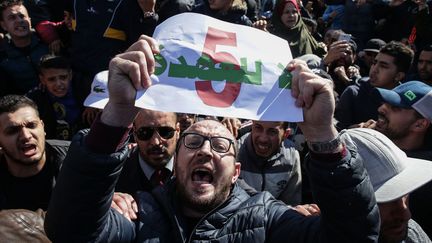 Un manifestant brandit une affiche contre le cinquième mandat du&nbsp;président Abdelaziz Bouteflika, vendredi 22 février 2019, à Alger (Algérie).&nbsp; (FAROUK BATICHE / DPA / AFP)