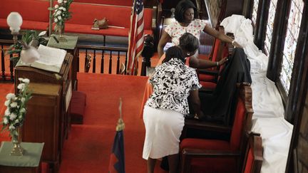 Un voile noir a &eacute;t&eacute; d&eacute;pos&eacute; sur le si&egrave;ge o&ugrave; prenait habituellement place le pasteur de la paroisse, Clementa Pinckney, &eacute;galement &eacute;lu d&eacute;mocrate du S&eacute;nat de Caroline du Sud, et tu&eacute; mercredi soir. (DAVID GOLDMAN / AP / SIPA)