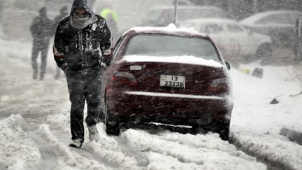 Une homme marche sous une temp&ecirc;te de neige mercredi 9 janvier 2013 &agrave; Amman, en Jordanie.&nbsp; (KHALIL MAZRAAWI / AFP)