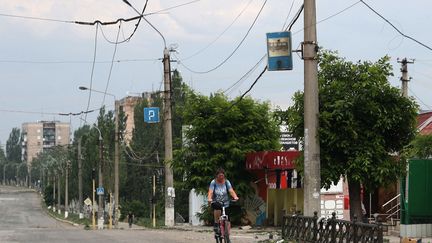 Une habitante de Lyssytchansk fait du vélo dans une rue, le 23 juin 2022, dans la région ukrainienne de Louhansk. (photo d'illustration) (ANATOLII STEPANOV / AFP)