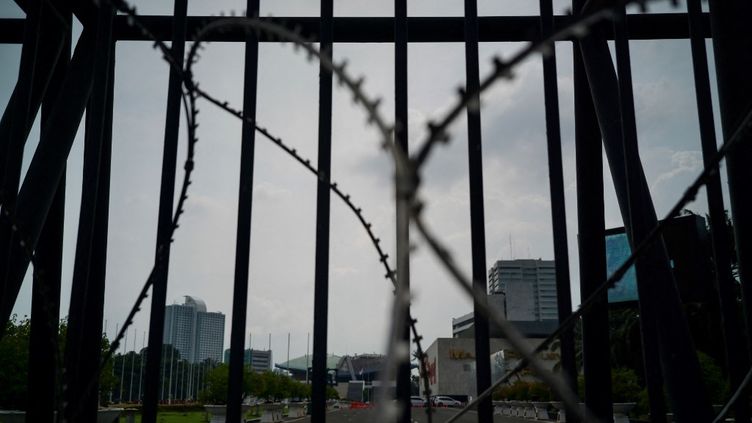 Des barbelés sur la porte du Parlement indonésien, à Jakarta, la capitale indonésienne, le 6 décembre 2022. (BAY ISMOYO / AFP)