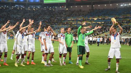 Le d&eacute;fenseur allemand Benedikt H&ouml;wedes brandit le troph&eacute;e avec ses co&eacute;quipiers, dimanche 13 juillet &agrave; Rio. Favorite en finale, l'Allemagne a eu peur face &agrave; l'Argentine. (PATRIK STOLLARZ / AFP)