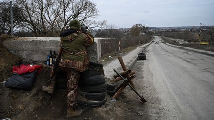 Un soldat ukrainien tient la garde dans la commune de&nbsp;Stoyanka, près de Kiev (Ukraine), le 6 mars 2022. (ARIS MESSINIS / AFP)