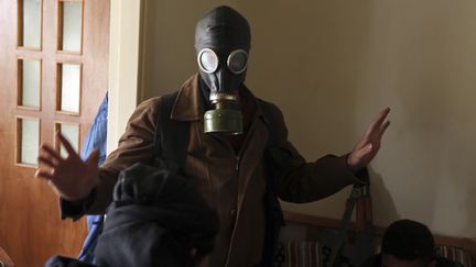 Un combattant de l'Arm&eacute;e syrienne libre &eacute;quip&eacute; de masque &agrave; gaz, non loin de Damas, le 27 janvier 2013. (GORAN TOMASEVIC / REUTERS)