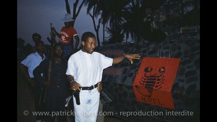 Charles Taylor devant le sigle de son mouvement rebelle, le NPFL, à Gborplay (Libéria) le 5 juin 1990 (photo Patrick Robert /corbis/Sygma)