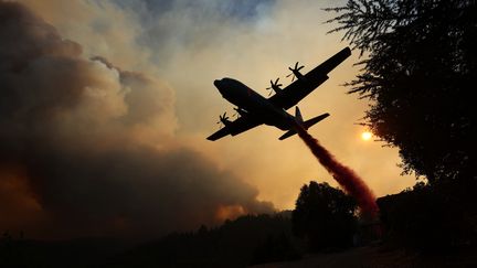 Un avion C-130 lance une susbtance ignifuge pour retarder les feux de Headsburg en Californie, le 20 août 2020.&nbsp; (JUSTIN SULLIVAN / GETTY IMAGES NORTH AMERICA / AFP)