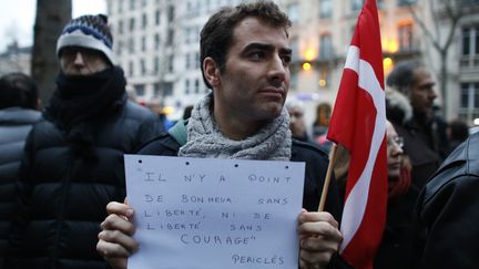 Un homme participe &agrave; un rassemblement devant l'ambassade du Danemark &agrave; Paris, le 15 f&eacute;vrier 2015, en hommage aux victimes des attentats commis &agrave; Copenhague la veille. (THOMAS SAMSON / AFP)