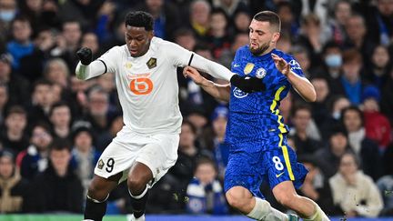 Le Lillois Jonathan David au duel avec Mateo Kovacic lors du huitième de finale aller de la Ligue des champions entre Chelsea et le Losc, le 22 février 2022 à Londres. (JUSTIN TALLIS / AFP)