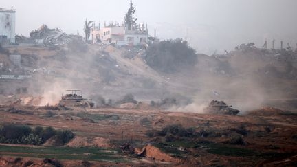 A photo taken on January 9, 2024 from the Israeli border shows Israeli army tanks driving through the center of the Gaza Strip.  (MENAHEM KAHANA / AFP)