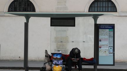 Un sans-abri, assis à un abri-bus, le 22 mars 2020 à Paris. Photo d'illustration. (LUDOVIC MARIN / AFP)