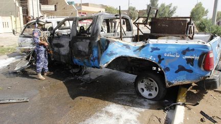 Un policier inspecte un v&eacute;hicule &agrave; Kirkouk, &agrave; 250 km au nord de Bagdad, apr&egrave;s un attentat le 15 juillet 2013. L'Irak est confront&eacute; &agrave; une vague de violences. (© STRINGER IRAQ / REUTERS / X80014)