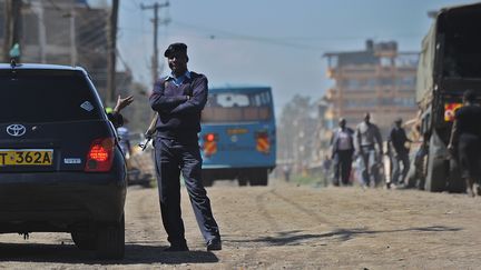 Un officier de police,&nbsp;le 9 avril 2014, dans une rue de Nairobi, pr&egrave;s du quartier somalien o&ugrave; a explos&eacute; une voiture pi&eacute;g&eacute;e. (TONY KARUMBA / AFP)