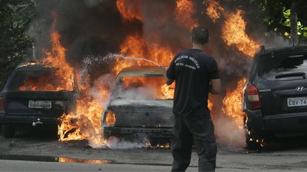 Trois voitures en feu dans les rues de Rio de&nbsp;Janeiro (Br&eacute;sil), le 28 avril 2014. (ALESSANDRO COSTA / AGENCIA O DIA/ESTADAO CONTEUDO / AFP)