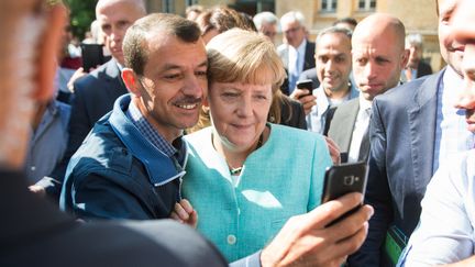 La chancelière allemande Angela Merkel&nbsp;pose avec des réfugiés,&nbsp;lors d'une réception dans un centre pour demandeurs d'asile, le 10 septembre 2015 à Berlin. (BERND VON JUTRCZENKA / DPA / AFP)