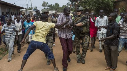 Un homme s'en prend &agrave; un milicien pr&eacute;sum&eacute; de l'ex-S&eacute;l&eacute;ka, arr&ecirc;t&eacute; par des soldats fran&ccedil;ais, le 9 d&eacute;cembre 2013 &agrave; Bangui (Centrafrique). (FRED DUFOUR / AFP)