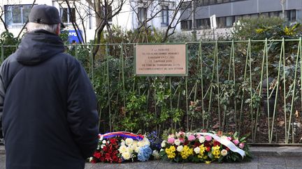 Un passant se recueille devant la plaque en mémoire du policier&nbsp;Ahmed Merabet, à Paris le 5 janvier 2017. (ERIC FEFERBERG / AFP)