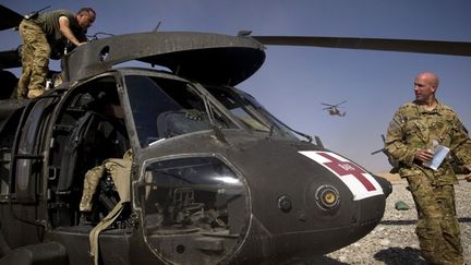 Le pilote, l'adjudant-chef Daniel Nickolaus, et le commandant, l'adjudant-chef John Otremba, vérifient le système hydraulique, avant la tombée de la nuit. ( AFP PHOTO/BEHROUZ MEHR)