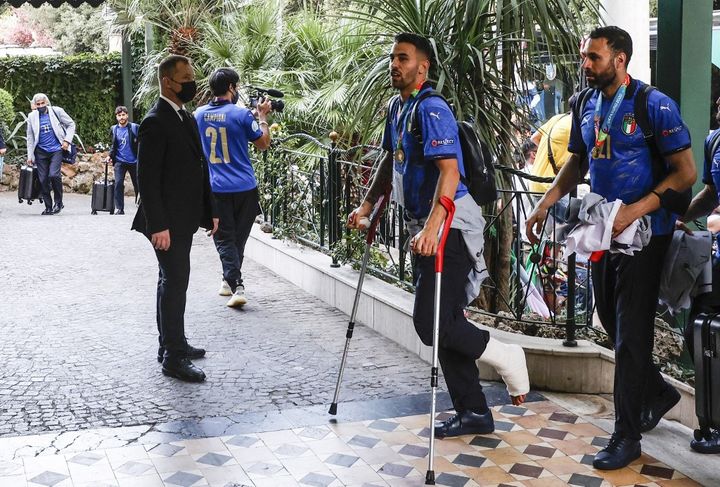 Leonardo Spinazzola lors de son arrivée à l'hôtel en béquilles, après avoir atteri à Rome, le 12 juillet 2021. (RICCARDO DE LUCA / ANADOLU AGENCY)