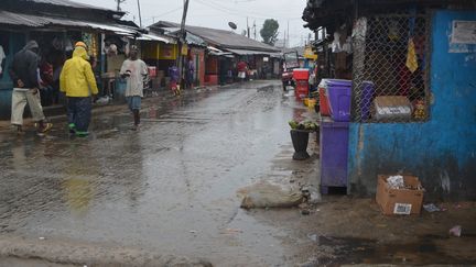 Des personnes marchent sous la pluie dans une rue de Monrovia, le 17 ao&ucirc;t 2014. (ZOOM DOSSO / AFP)