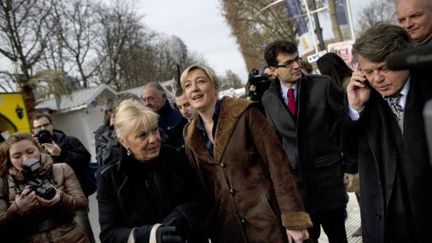 Marine Le Pen (au centre) et Me Gilbert Collard (à droite) arpentent le marché de Noël des Champs-Elysées. (FRED DUFOUR / AFP)