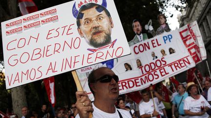 Un homme tient une affiche qui diabolise le Premier ministre Mariano Rajoy jeudi 19 juillet. (SUSANA VERA / REUTERS)