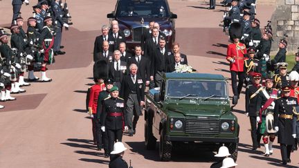 Le&nbsp;cercueil a été levé pour être placé à l'arrière d'un Land Rover vert militaire que le prince Philip avait lui-même contribué à concevoir pendant 16 ans. La procession s'est faite au son de la fanfare des Grenadier Guards, dont Philip a été le colonel pendant 42 ans (HANNAH MCKAY / POOL / AFP)