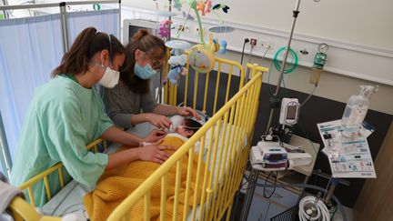 Une infirmière et une mère au chevet d'un enfant atteint de bronchiolite, à l'hôpital Pasteur de Colmar (Haut-Rhin). (HERVE KIELWASSER / MAXPPP)